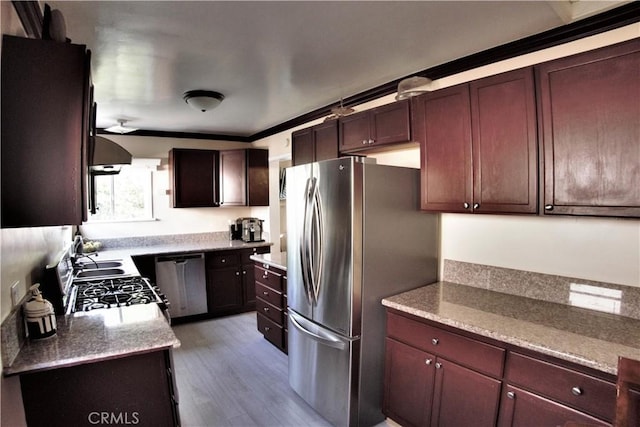 kitchen with appliances with stainless steel finishes, extractor fan, and wood finished floors