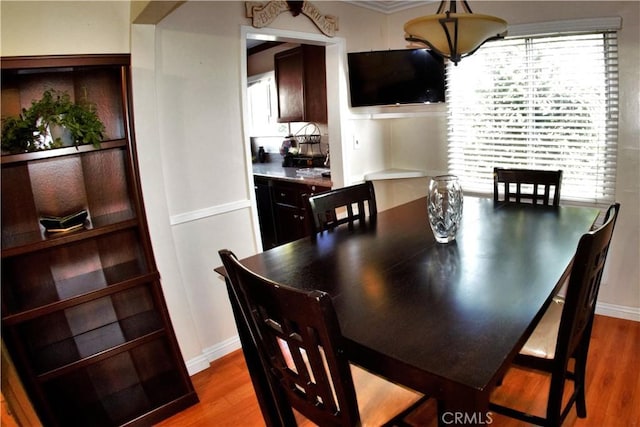 dining space with wood finished floors and baseboards