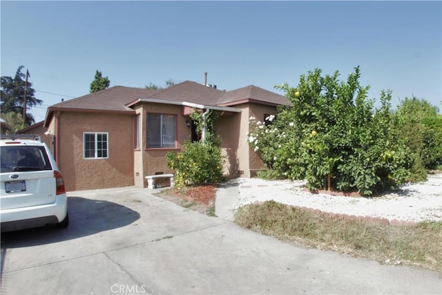 view of front of property featuring concrete driveway and stucco siding