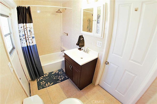 bathroom with tile patterned flooring, shower / bathtub combination with curtain, and vanity