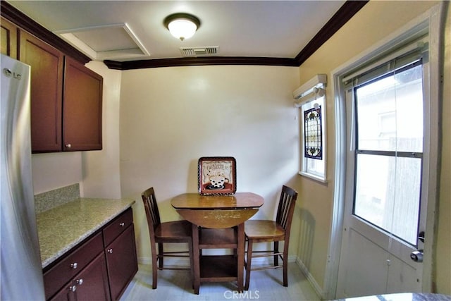 dining area with baseboards, visible vents, and crown molding