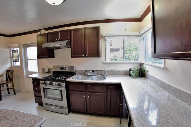 kitchen featuring dark brown cabinetry, stainless steel range with gas stovetop, crown molding, under cabinet range hood, and a sink