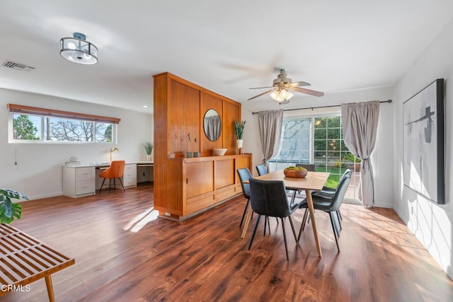 dining space with a wealth of natural light, visible vents, baseboards, and wood finished floors