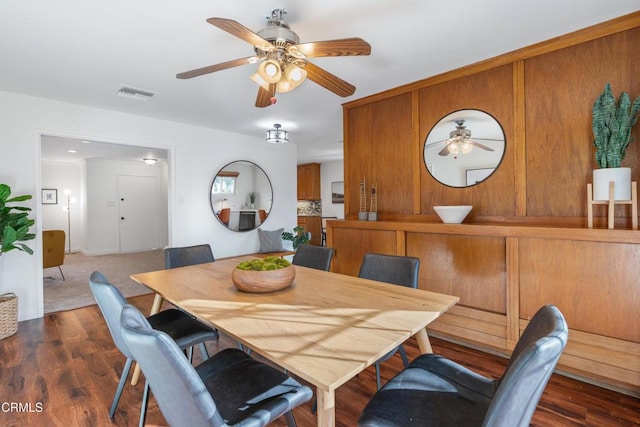 dining area featuring dark wood-type flooring, a ceiling fan, and visible vents