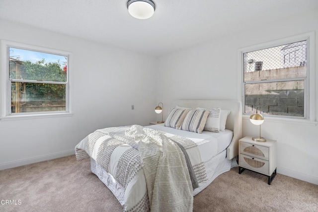 bedroom featuring baseboards and carpet