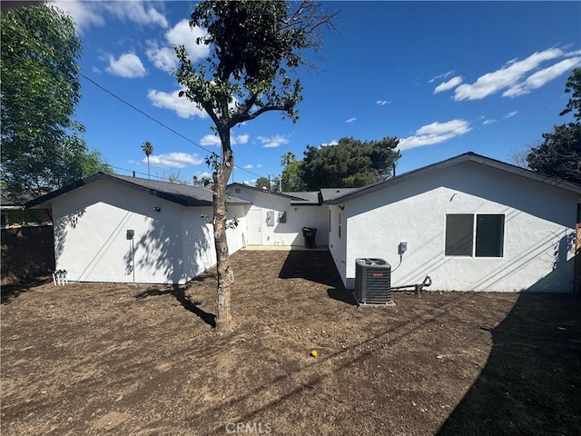 back of property with cooling unit and stucco siding