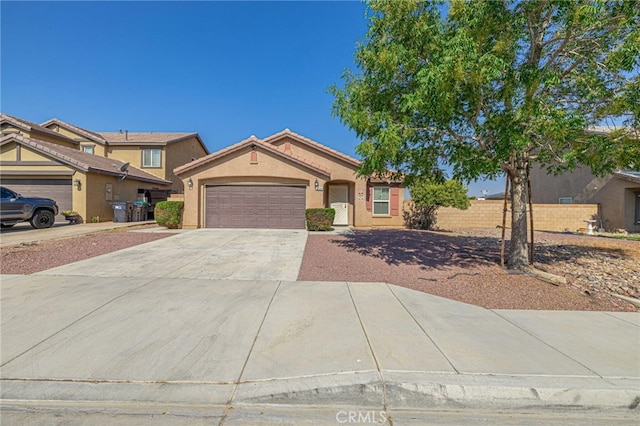 ranch-style home with a tile roof, stucco siding, an attached garage, fence, and driveway