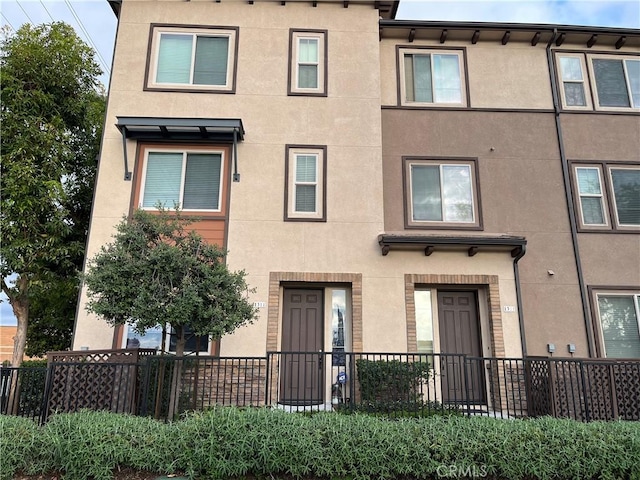 multi unit property with fence and stucco siding