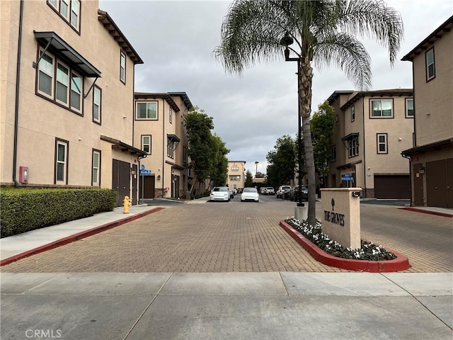 view of road with street lights, curbs, and sidewalks