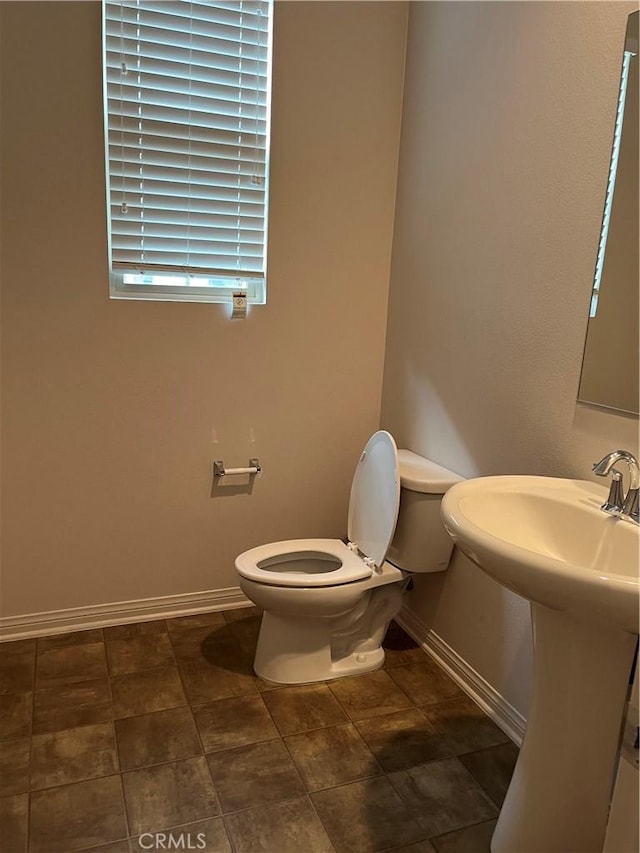 half bath with toilet and baseboards