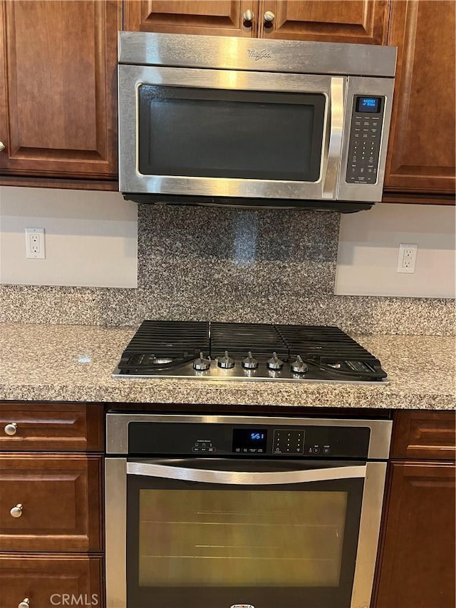 kitchen featuring light countertops, appliances with stainless steel finishes, and dark brown cabinets