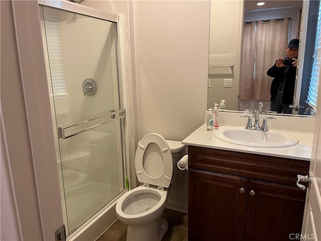 bathroom with a stall shower, vanity, toilet, and tile patterned floors