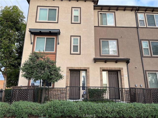 view of property featuring fence and stucco siding