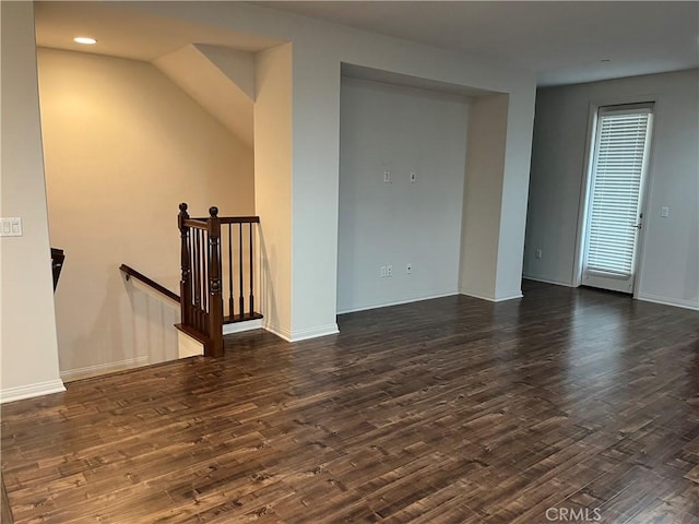 empty room featuring baseboards, dark wood-type flooring, and recessed lighting