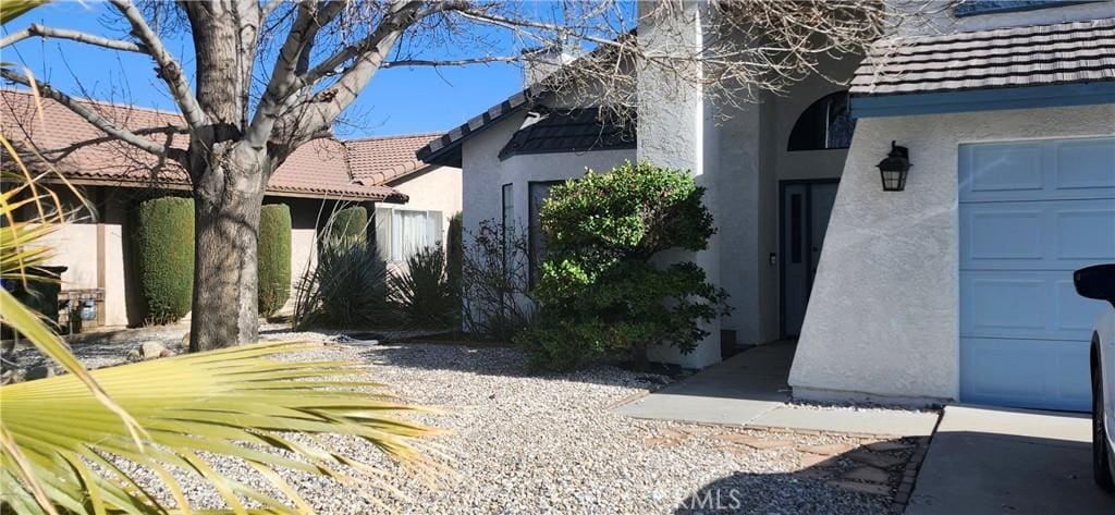 view of side of property featuring a tile roof and stucco siding