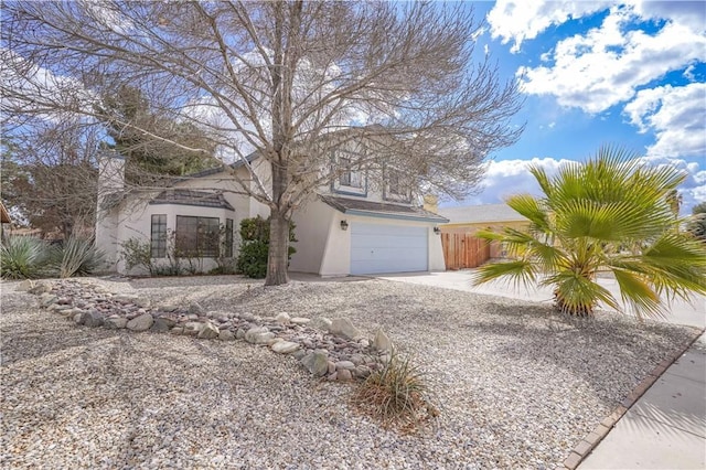 view of front of property with an attached garage, fence, concrete driveway, and stucco siding