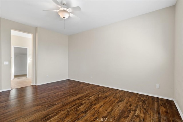 empty room with wood-type flooring, a ceiling fan, and baseboards