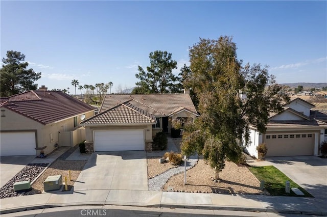 view of front of home with a tile roof, stucco siding, concrete driveway, a garage, and stone siding