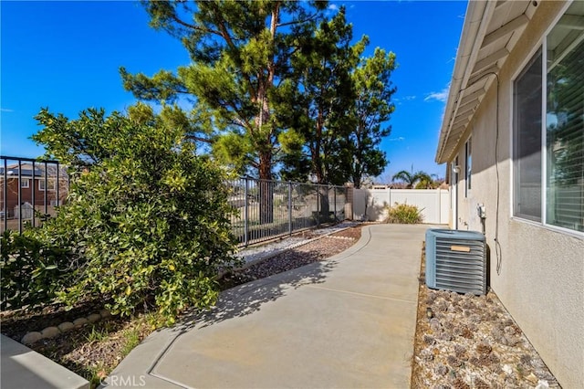 exterior space with a patio area, a fenced backyard, and cooling unit