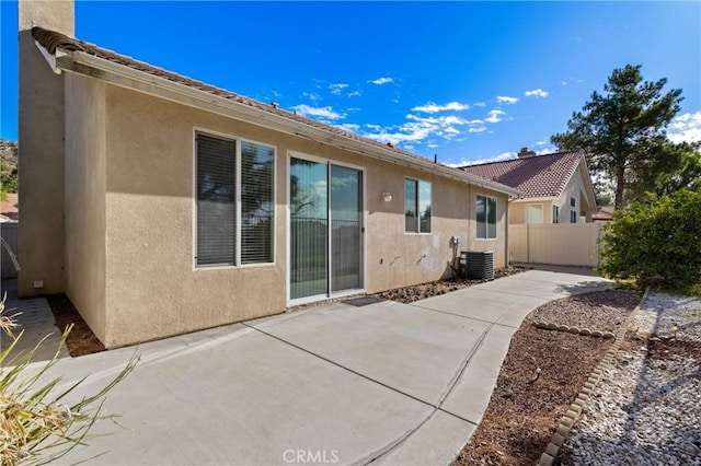 back of house with cooling unit, a patio, fence, and stucco siding