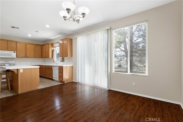 kitchen with light countertops, visible vents, light wood-style floors, a chandelier, and white appliances