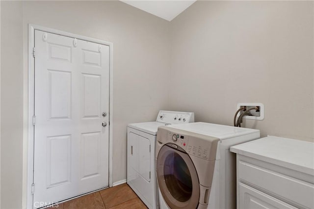 washroom with laundry area, washer and clothes dryer, and light tile patterned floors