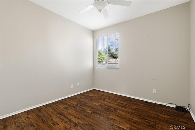 spare room featuring dark wood-type flooring, baseboards, and a ceiling fan