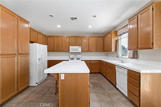 kitchen with white appliances, visible vents, tile countertops, a kitchen island, and a sink