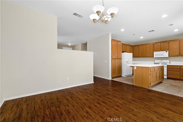 kitchen with light countertops, white appliances, visible vents, and light wood-style flooring