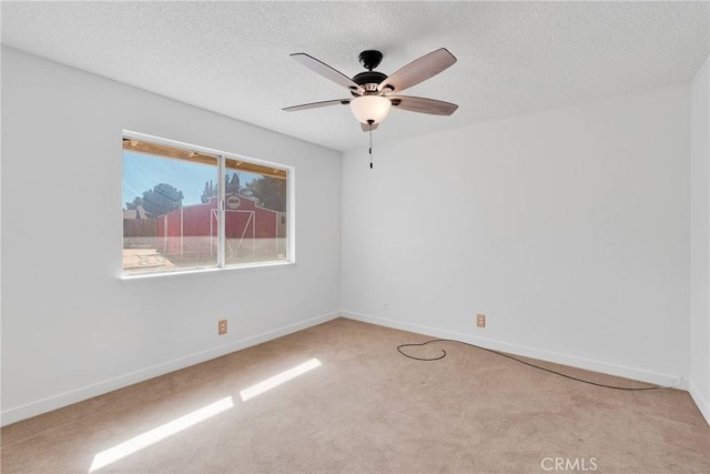 unfurnished room with a ceiling fan, carpet, a textured ceiling, and baseboards