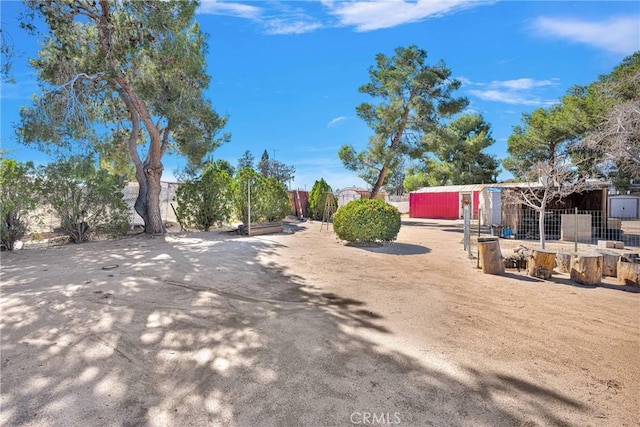 view of yard featuring an outdoor structure and fence