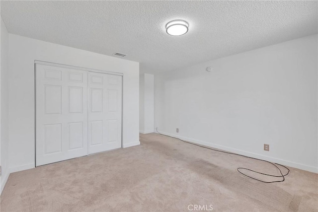 unfurnished bedroom featuring carpet floors, a closet, visible vents, and baseboards