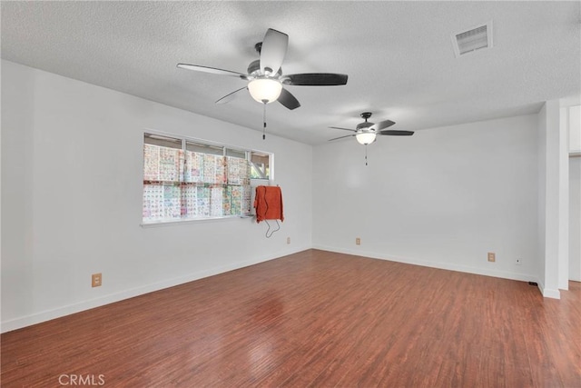 unfurnished room with visible vents, a ceiling fan, a textured ceiling, wood finished floors, and baseboards