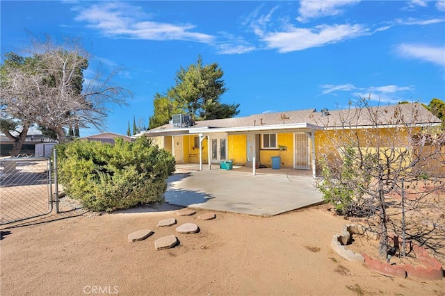 back of property featuring central AC, french doors, fence, and a gate