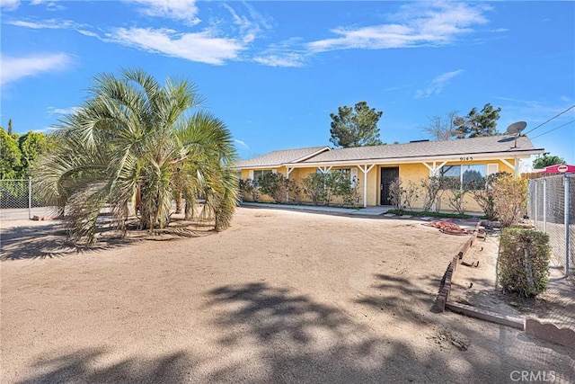 view of front facade featuring fence and stucco siding