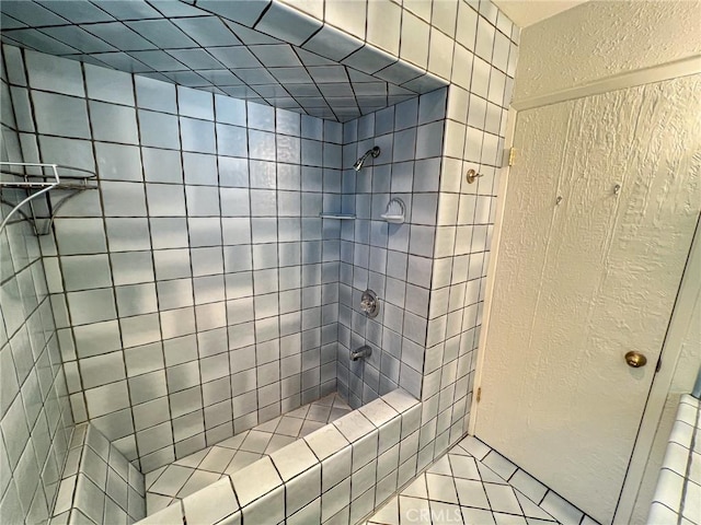 full bath featuring a textured wall and a tile shower