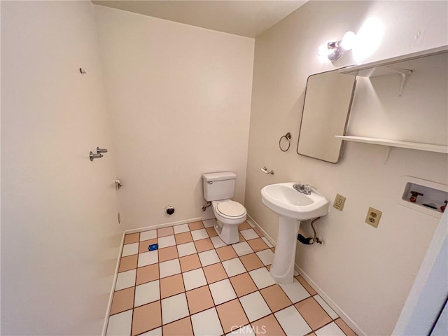 bathroom with baseboards, a sink, and toilet