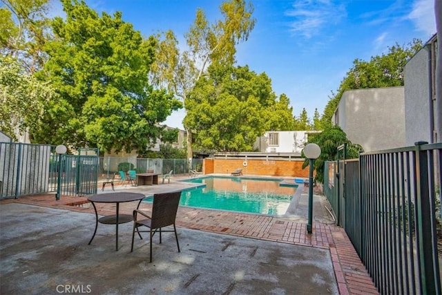 view of swimming pool featuring a patio area, fence, and a fenced in pool