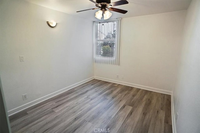 spare room featuring a ceiling fan, baseboards, and wood finished floors