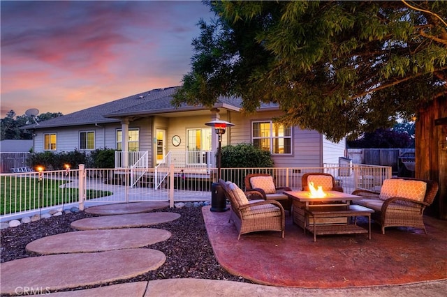 view of front of property featuring a patio area, an outdoor fire pit, and fence