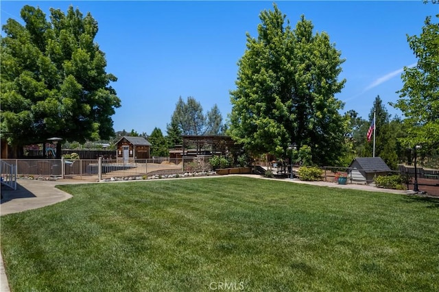 view of yard featuring a storage shed, fence, and an outbuilding