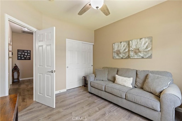 living area with light wood-style floors, baseboards, visible vents, and a ceiling fan