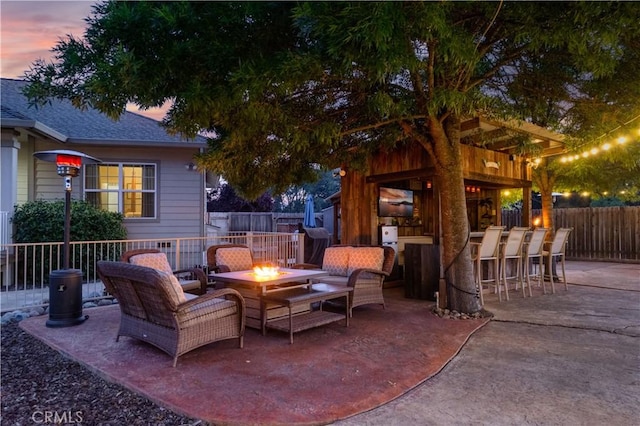 view of patio featuring outdoor dry bar, a fenced backyard, and a fire pit