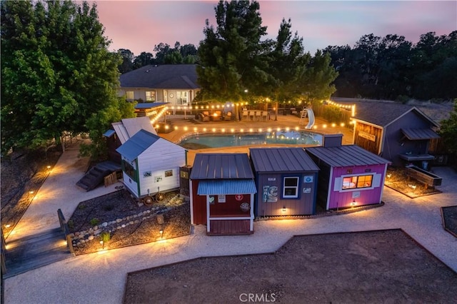 view of front of home with metal roof, a standing seam roof, board and batten siding, and an outdoor pool