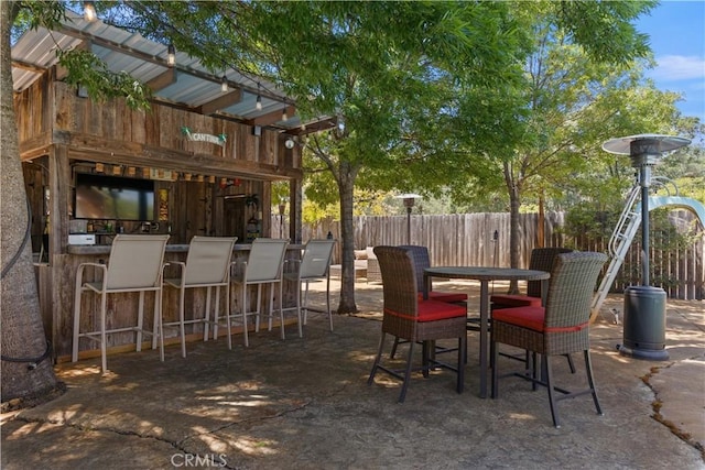 view of patio / terrace featuring outdoor dry bar and fence