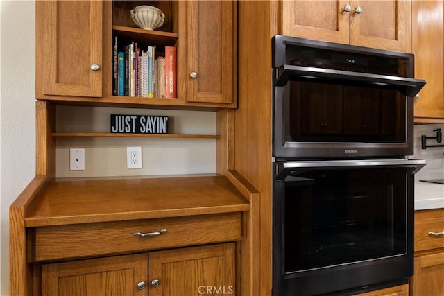 kitchen featuring open shelves, double oven, and brown cabinets