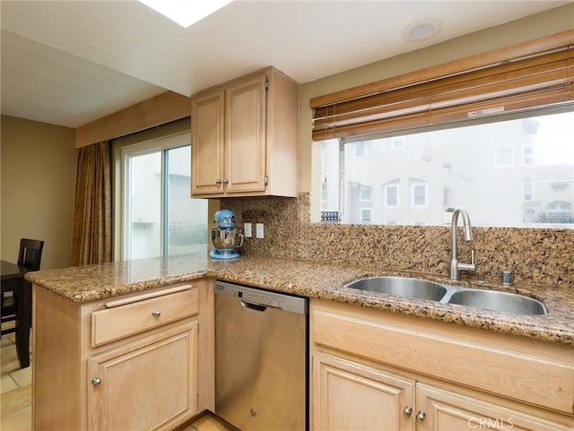 kitchen with a wealth of natural light, light brown cabinets, a sink, and stainless steel dishwasher