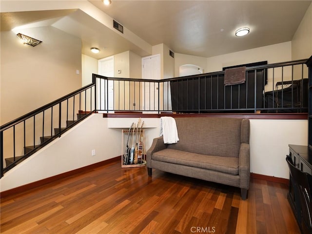 living area featuring stairway, wood finished floors, visible vents, and baseboards