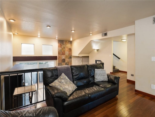 cinema room with wood-type flooring, visible vents, and baseboards