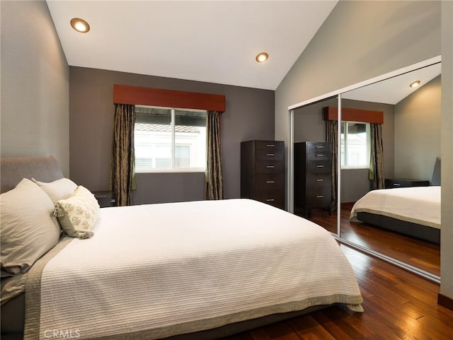 bedroom with dark wood-type flooring, recessed lighting, a closet, and vaulted ceiling